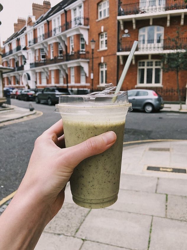 photo of person holding a cup of matcha smoothie